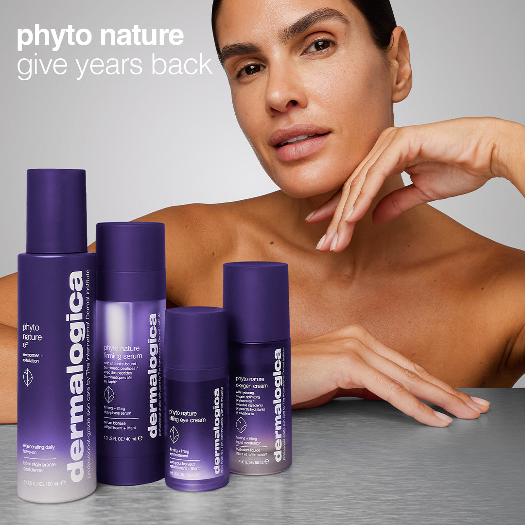 A woman with glowing skin poses behind five purple Dermalogica South Africa phyto nature e² regenerating daily exosome leave-on treatments on a gray surface, with “phyto nature give years back” in the top left corner.