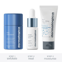 The Dermalogica hydration on-the-go set (3 travel size) includes an oat-based powder exfoliant, hydrating serum with dropper, and skin smoothing cream, all displayed before branded packaging with a blue R799 price label.