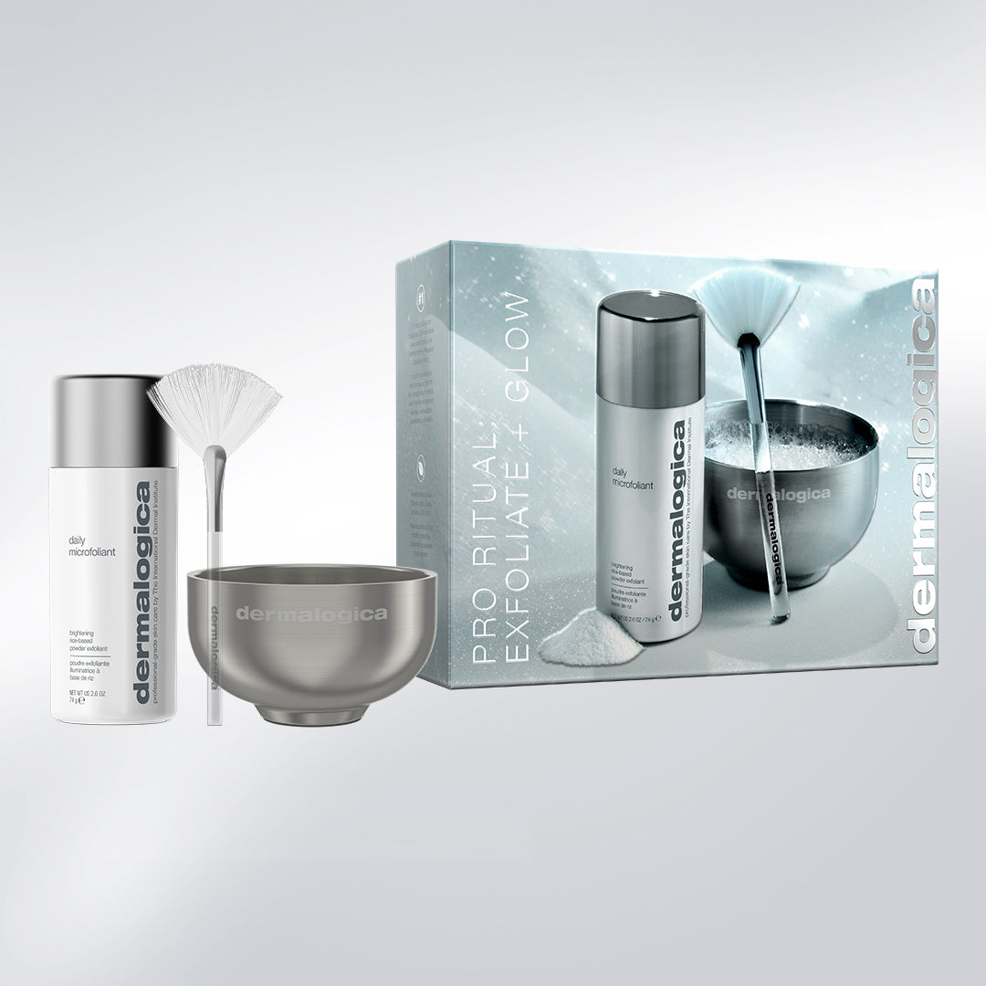 A Dermalogica South Africa pro ritual: exfoliate + glow set (full-size + mixing bowl + fan brush) containing an exfoliating powder, a fan-shaped brush, and a mixing bowl, displayed next to its product packaging to help achieve glowing skin.