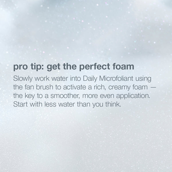A fan brush and water create a creamy foam with Daily Microfoliant from the pro ritual: exfoliate + glow set for glowing skin.
