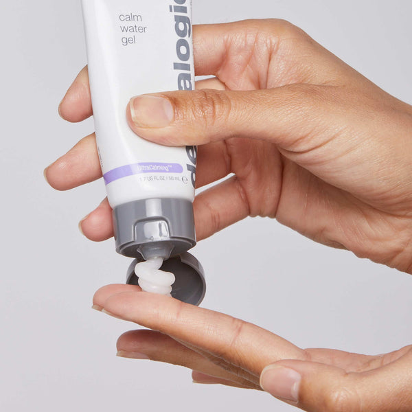 A hand squeezes Dermalogica’s calm water gel from a white and gray tube onto a fingertip, showcasing this hydrating water-gel moisturizer for dry skin against a plain light background.