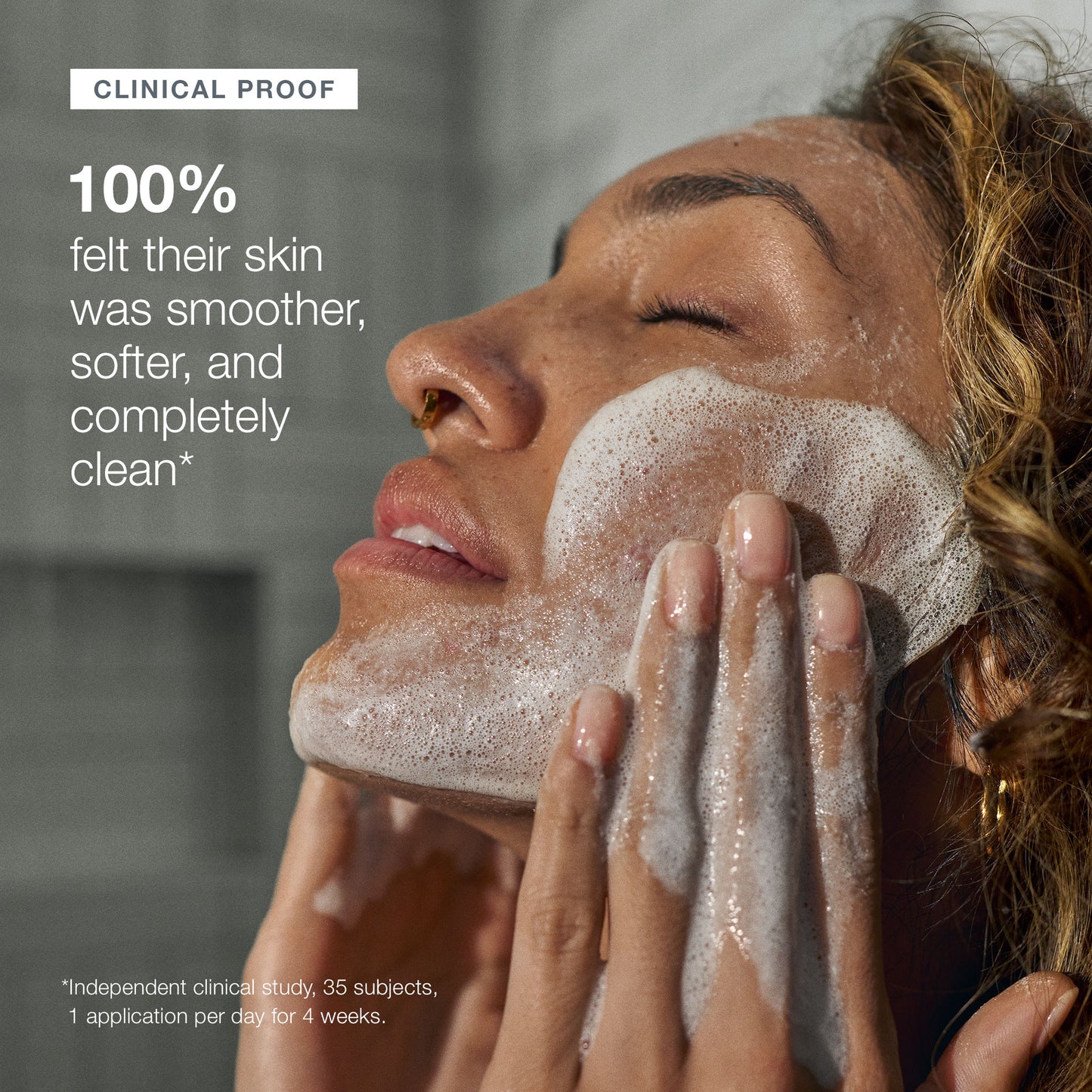 With eyes closed, a person gently massages Dermalogica daily microfoliant onto their face. Text highlights clinical proof: 100% felt their skin was smoother, softer, and completely clean after using the exfoliating cleanser.