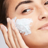 A tube of Dermalogica hydro masque exfoliant features blue gel with exfoliating bamboo beads, a gray and white cap, vertical Dermalogica branding, and hydrating benefits from snow mushroom extract.
