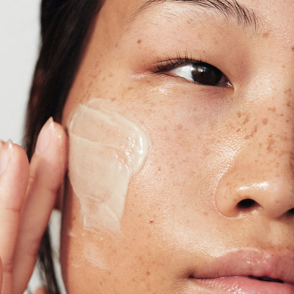 A close-up shows someone applying Dermalogica South Africa’s powerbright dark spot peel 50ml to their cheek, suggesting its use on dewy, freckled skin to target dark spots and hyperpigmentation for a radiant complexion.