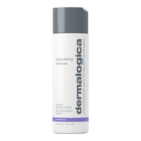 A 500ml white pump bottle of Dermalogica ultracalming cleanser features bold gray vertical branding, purple accents, and a gray pump. This pH-balanced formula gently soothes and cleanses sensitive skin.