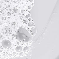 A clear pump bottle of Dermalogica conditioning body wash with a silver dispenser holds light yellow liquid. The label features essential oils such as eucalyptus and lavender, offering a nourishing cleanse for the skin.